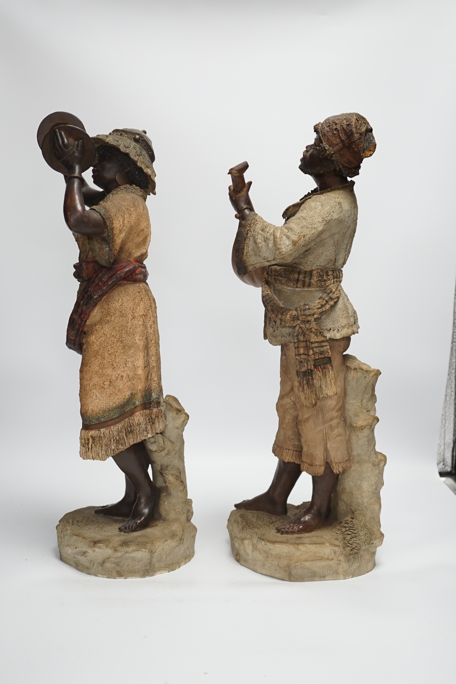 A pair of late 19th century Continental cold painted terracotta Nubian musician figures, 49cm